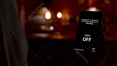 Bartender using a smart home application to turn ON the lights