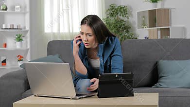 Worried woman using multiple devices