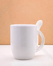 White coffee mug and spoon on backdrops. Ceramic tea cup for your design