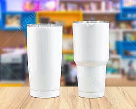 Stainless steel tumbler mug on wooden backdrops. Template of insulated mug for design