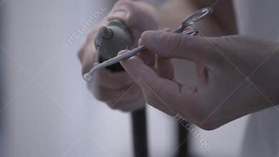 Dental technician polishing artificial ceramic teeth using compressed air blaster in the dental lab. Professional holding fake tee