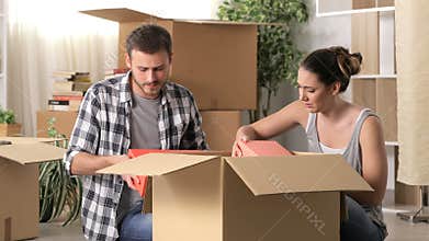 Sad couple boxing belongings moving home