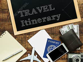 Travel itinerary handwritten with white chalk on a blackboard decorate with plane model, passport, money wallet , notebook