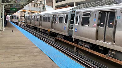 Two el trains arrive and depart the Adams/Wabash stations in Chicago`s loop.