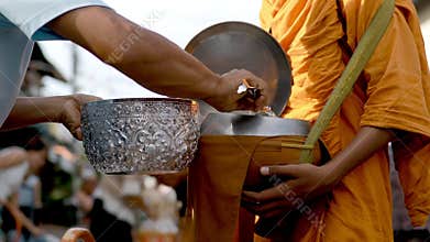 Thai people offering cooked rice to buddhist monk on early morning
