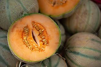 Open cut Charentais melon on market pile