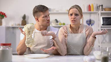 Chef holding raw dough, dissatisfied with work of kitchen novice, cuisine course