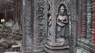 Sliding view of beautiful deity carving on Ta Prohm temple wall.