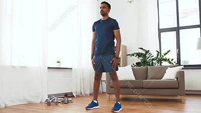 Indian man exercising and doing squats at home