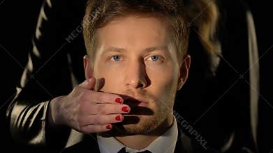 Woman closing male mouth, censorship concept, no personal opinion, closeup