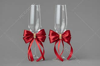 Two wedding wine glasses decorates with red bows.
