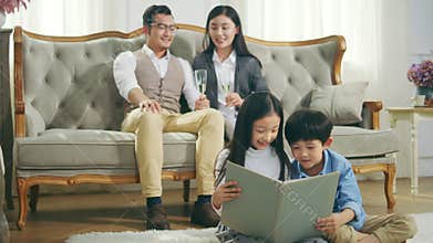 Little asian children sitting on carpet reading book