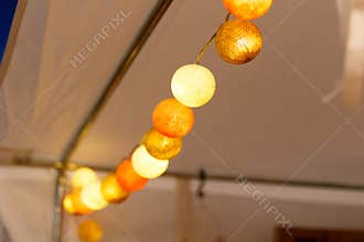Close up light bulbs of hanging decorative lights string for a party or ceremony, soft focus