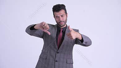 Confused bearded Persian businessman choosing between thumbs up and thumbs down