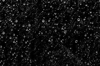 Hundreds of white rain drops on a window with a black background