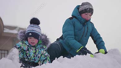 Children playing on a snowy mountain, throwing snow and smejutsja . Sunny frosty day. Fun and games in the fresh air.