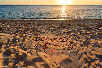 Handwritten happy birthday on sand beach