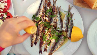 Eating appetizing sardines dish served with parsley and lemon