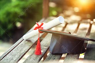 Graduation hat with tassel, diploma with red