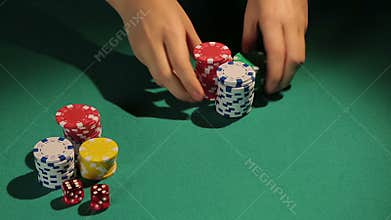 Hands of dealer giving poker chips to player, winner's gain in gamble, casino
