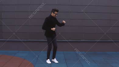 Happy dancer man wearing suit funky street dancing freestyle in the city