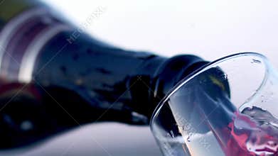 Red wine pouring into glass low angle view in slow motion. Fragolino