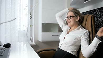 Slow motion video of cheerful businesswoman throwing papers in office and relaxing in chair