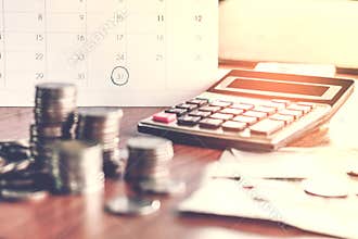 Debt collection and tax season concept with deadline calendar remind note,coins,banks,calculator on table
