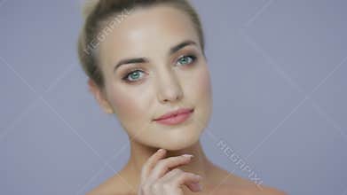 Cheerful blonde woman touching chin