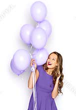 Happy girl in ultra violet dress with balloons