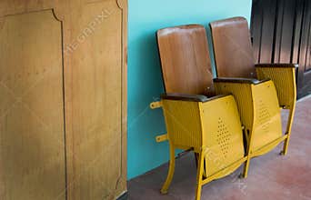 Close up of old wooden folding cinema chair or folding seat in front of Asian theater.