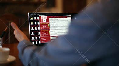 Man turns on a laptop waits for loading computer and finds out it is infected by a ransomware spyware virus that is