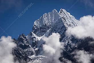 Thamserku montain peak above the clouds, Himalaya mountain range