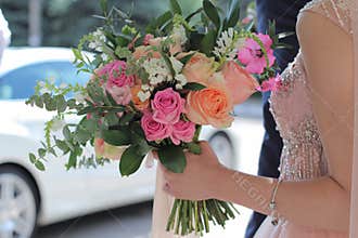 Beautiful bridal bouquet in hands of the bride. Wedding bouquet of peach roses by David Austin, single-head pink rose aqua, eucal