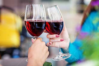 Glasses of red wine in their hands. Toast. The concept of party