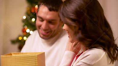 Happy couple with christmas gift at home