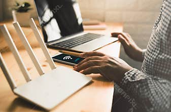 man using mobile with connect wifi on the screen. Man`s hands using device at Home office.