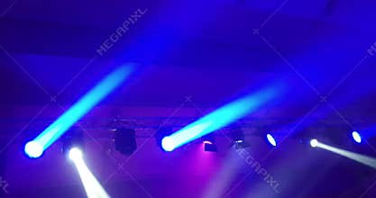 Abstract blue and violet purple, bright shiny stage lights flashing movement entertainment spotlight projectors in the dark