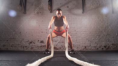 Cross fit battling ropes at gym workout exercise. Slow motion