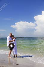 Senior couple embrace on beach