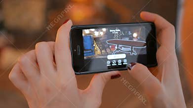 Woman using smartphone with augmented reality app and placing furniture in room