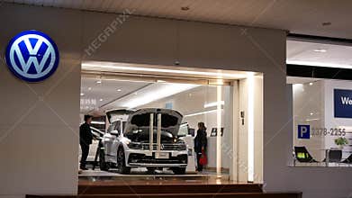 Motion of automobile dealership showroom with Volkswagen logo at night