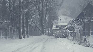 Snowy street of mountain town, snow calamity. Winter landscape with falling snow.