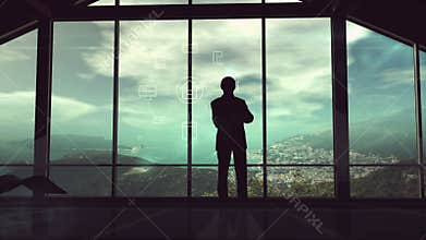 A man is standing by the window viewing IOT infographics elements