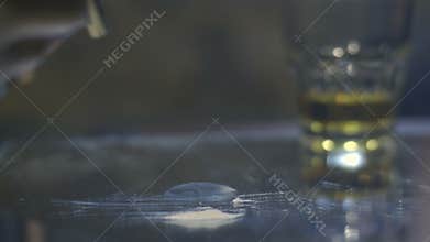 Close-up male sniffing cocaine line on mirror