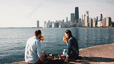 Romantic date on the shore of Michigan lake in Chicago, America. Beautiful couple enjoying a picnic together.