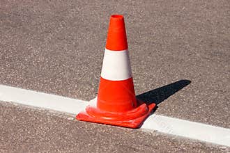 Work on road. Construction cone. Traffic cone, with white and orange stripes on asphalt. Street and traffic signs for signaling.