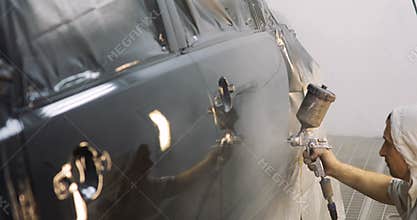 Footage of a car being painted and varnished in a painting chamber Lacquering a black car