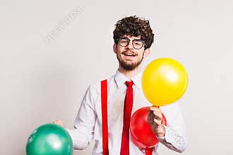 Portrait of a young man with balloons in a studio.