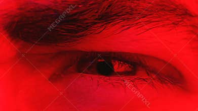 Macro closeup on man angry facial expression with his eye squinting